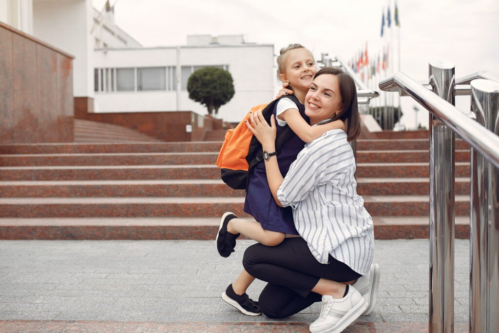 Madre acompañando y apoyando emocionalmente a su hija antes de la escuela.