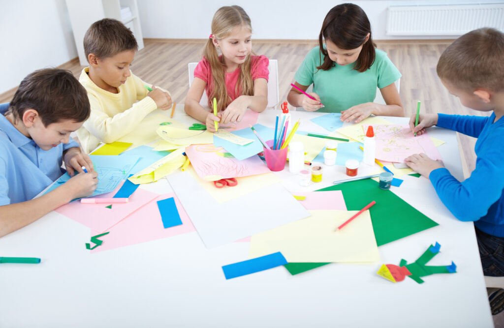 Niños sonriendo mientras realizan actividades educativas.
